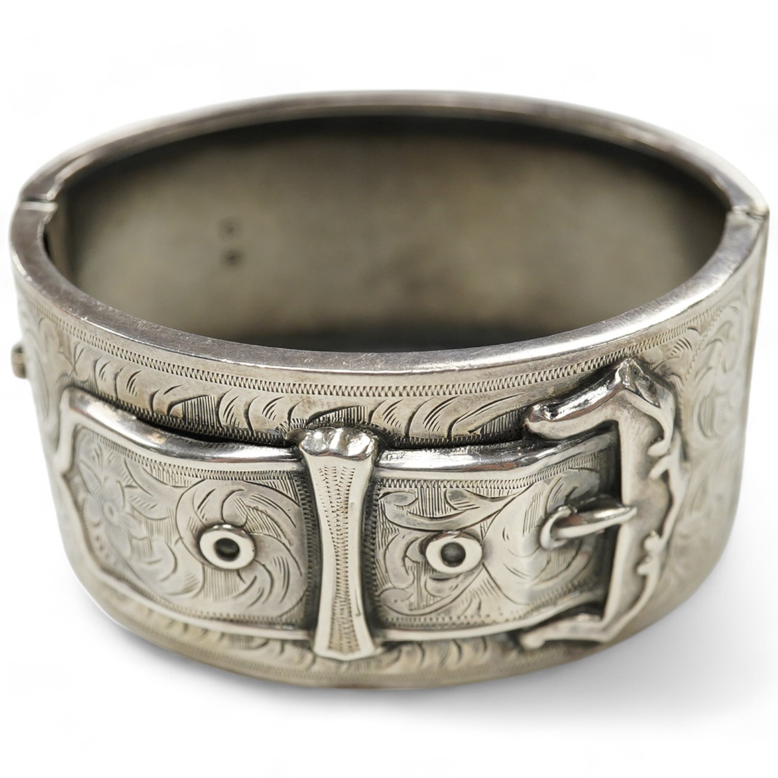A George V engraved silver hinged bangle, with 'buckle' decoration, Kirwan & Co Ltd, Birmingham, 1913. Condition - poor to fair